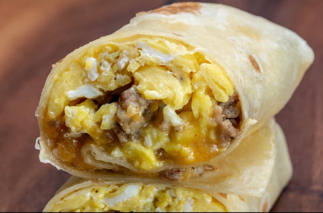Breakfast taco halves stacked, filled with egg, sausage and cheese