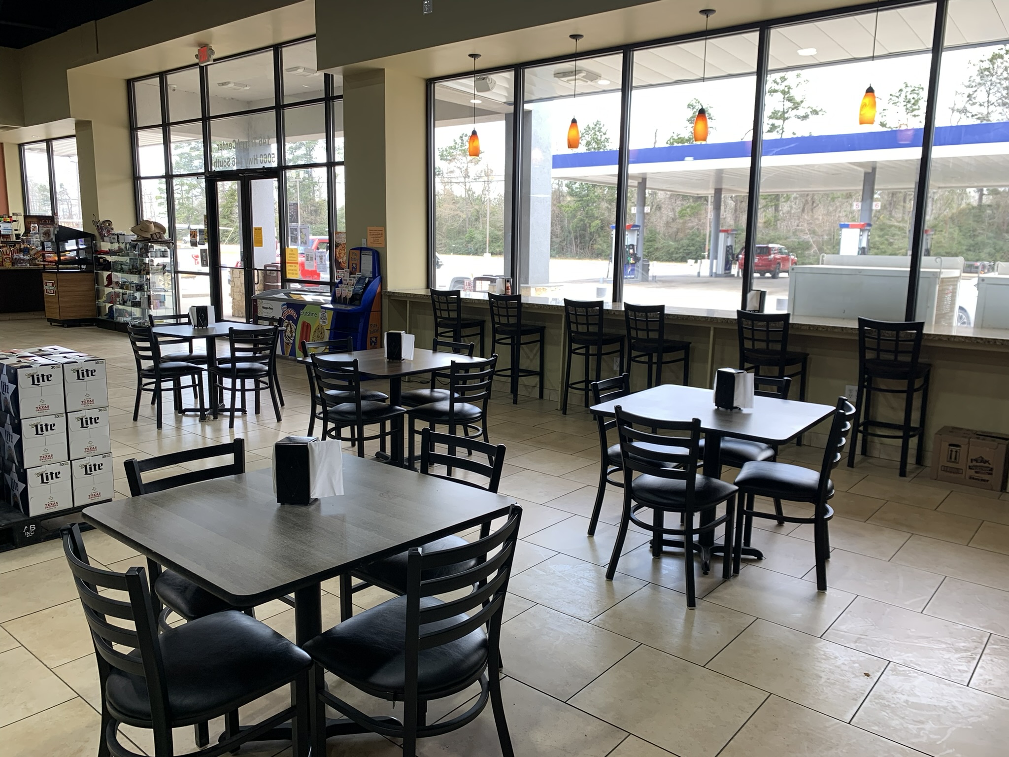 Dining area with tables and window seating facing the pumps